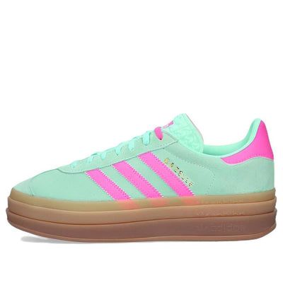 a green and pink adidas sneaker with gum soles on the outstep