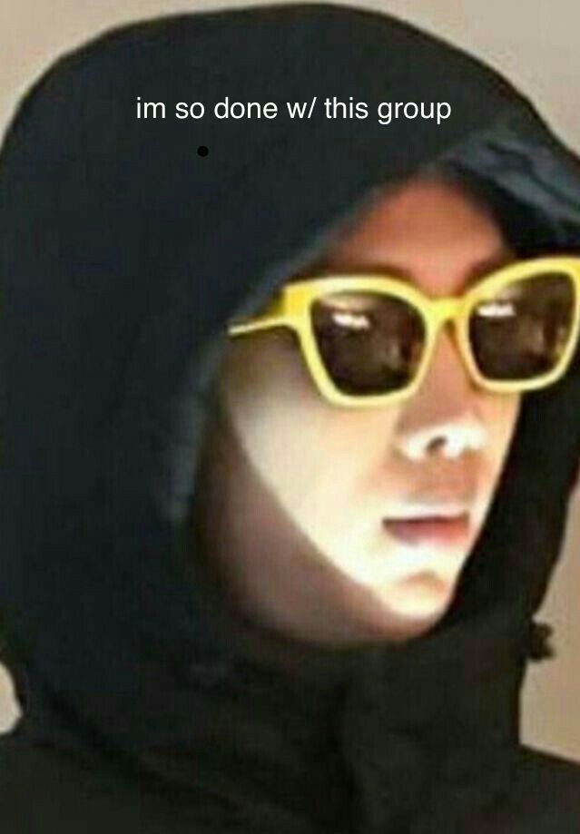 a man wearing yellow sunglasses and a black hoodie