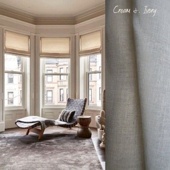 a living room filled with lots of windows next to a chair and ottoman in front of a window