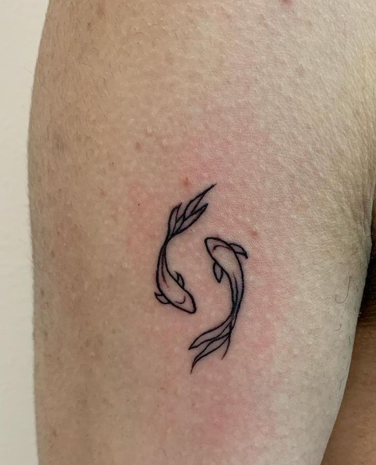 a small black and white koi fish tattoo on the right thigh, it's outline