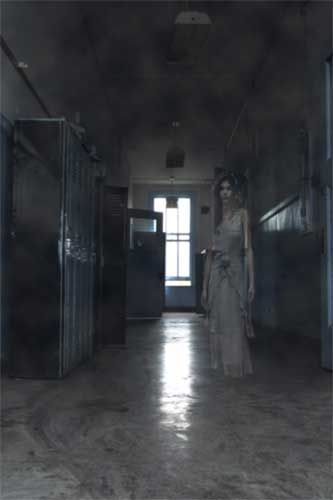 a woman in a long dress walking down a hallway