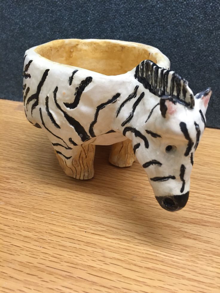 a ceramic zebra planter sitting on top of a wooden table