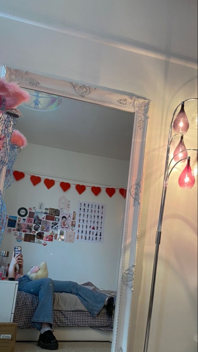 a person laying on the floor in front of a mirror with lights hanging from it