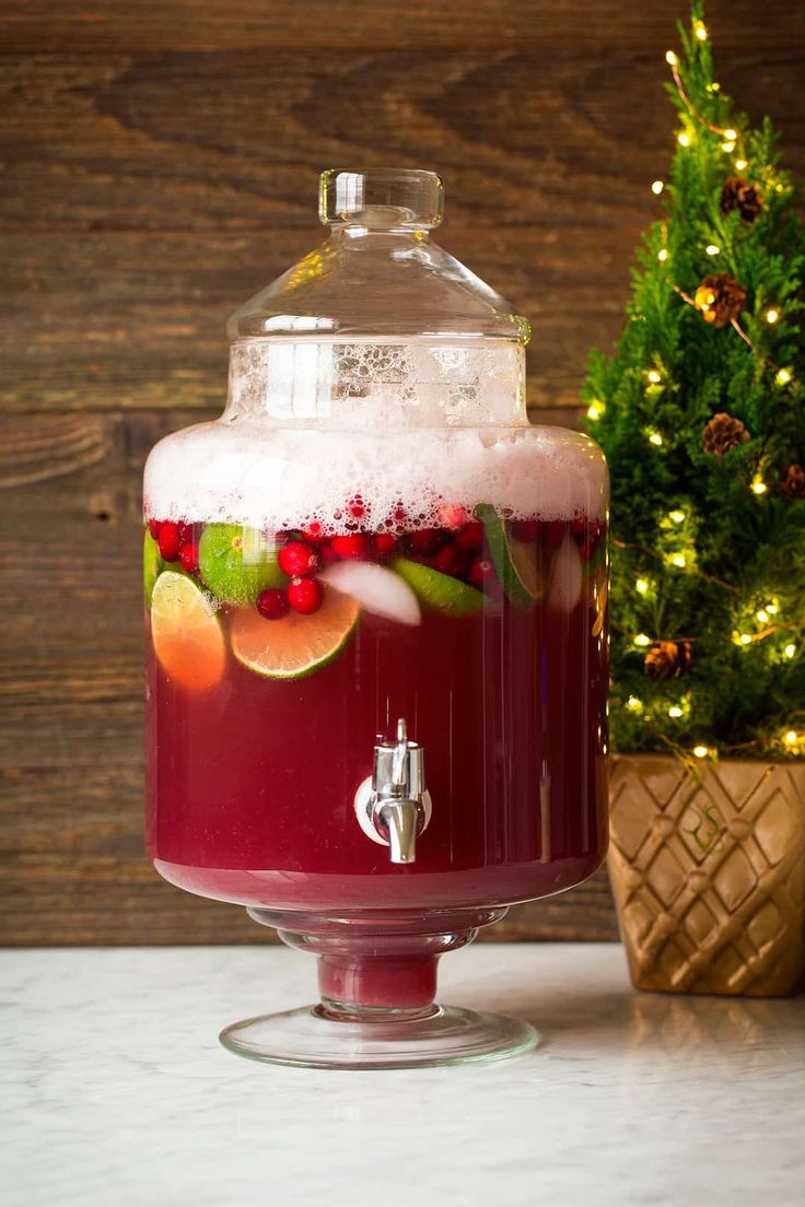 a bottle of liquid sitting on top of a table next to a christmas tree