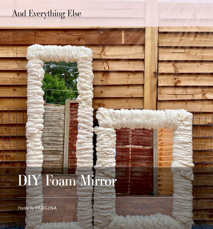 two mirrors made out of yarn sitting on top of a wooden floor next to a fence