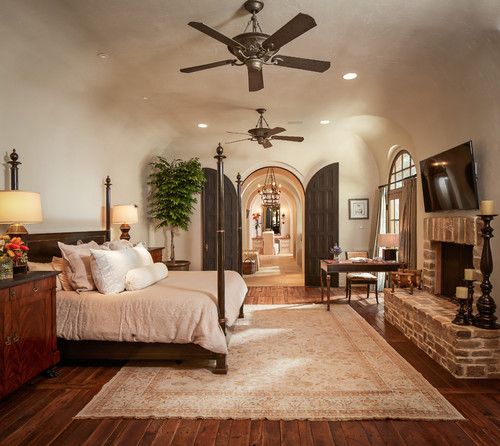 a large bedroom with a fireplace and bed