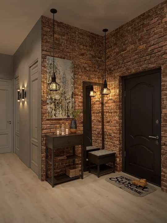 an empty room with brick walls and wooden flooring is lit up by two pendant lights