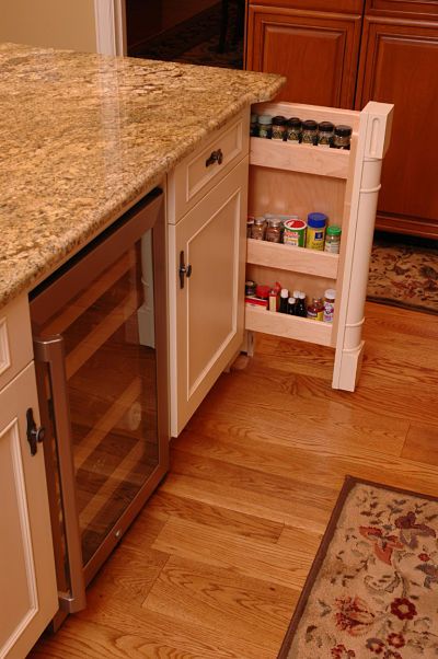 a kitchen with white cabinets and marble counter tops