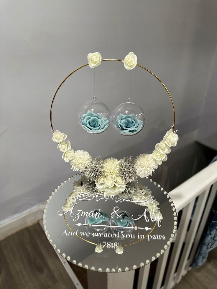 a glass display with flowers and pearls on it