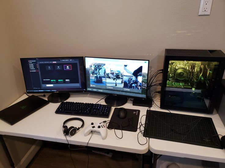 three computer monitors sitting on top of a white desk