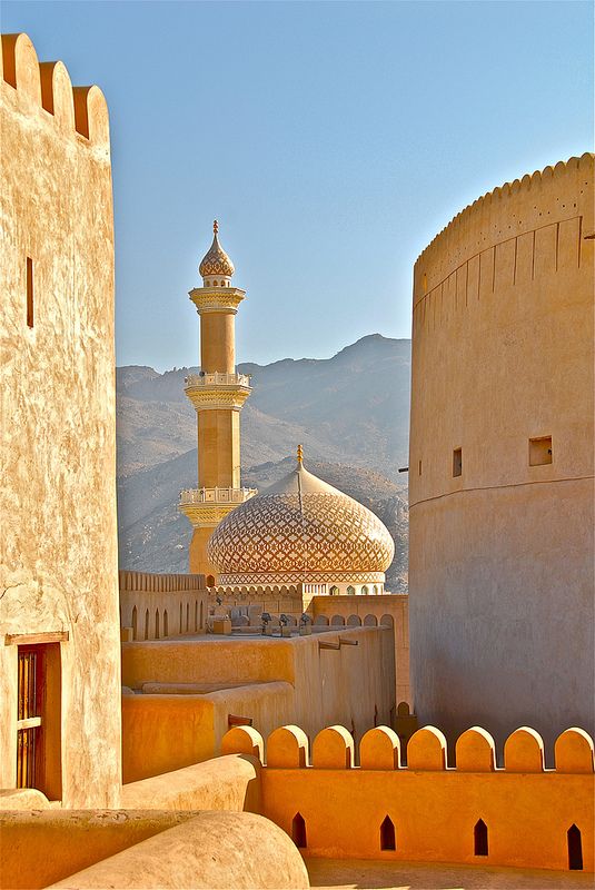 an old building in the desert with mountains in the background