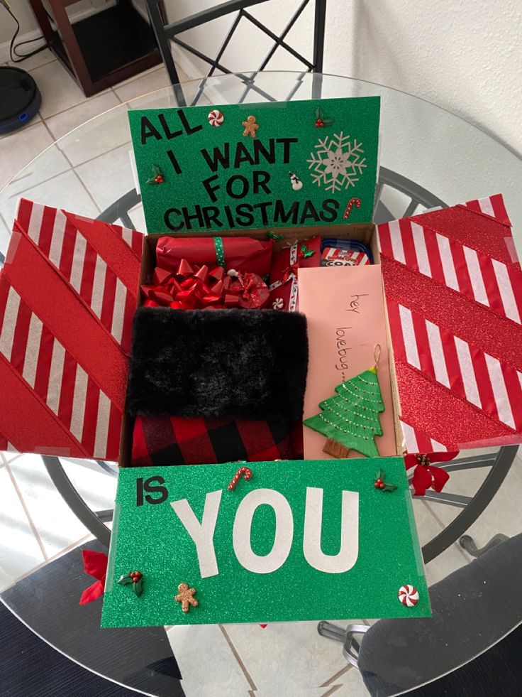 a christmas card box filled with lots of holiday cards and presents on top of a glass table