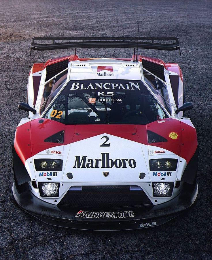 a red and white race car sitting on top of a parking lot