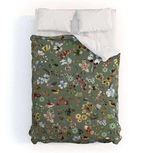 a bed covered in a green floral comforter