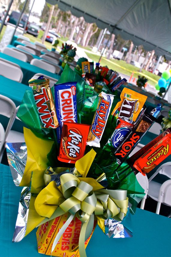 a bouquet of candy wrapped in cellophane and tied to a table with chairs