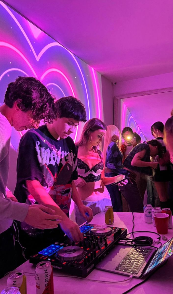 a group of people standing in front of a table with laptops and sound equipment