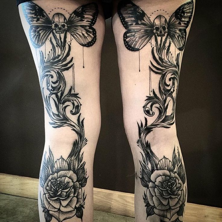 a woman's legs with black and white tattoos on them, butterflies and roses