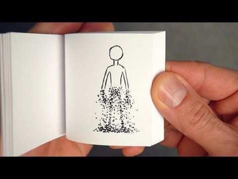 a hand holding an open book with a drawing of a person in the middle of it