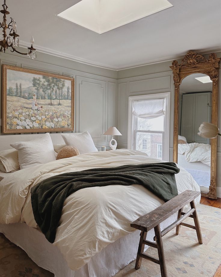 a large bed sitting in a bedroom next to a window with a painting on the wall