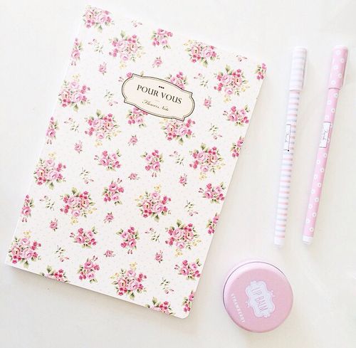 a notebook, pen and eraser sitting on top of a white table next to it