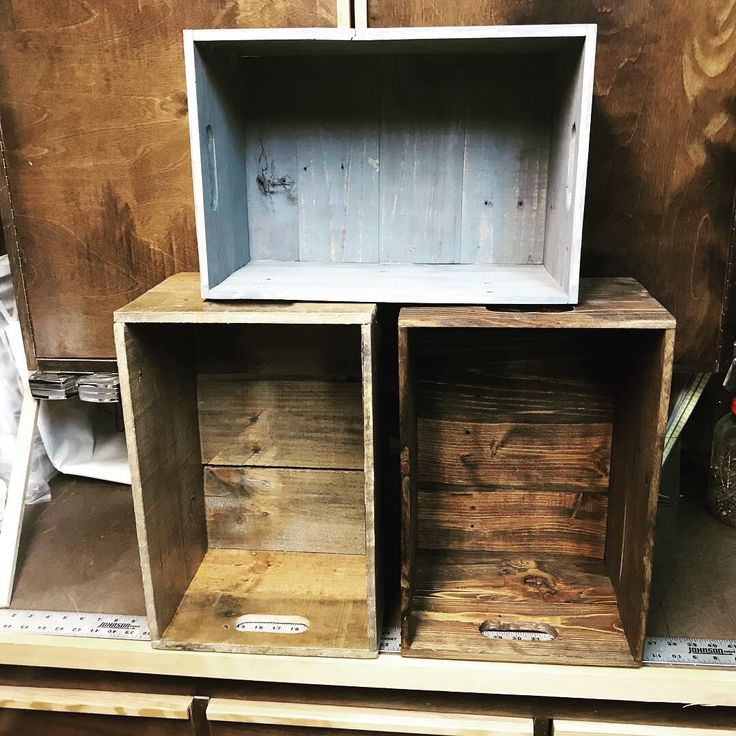 three wooden boxes stacked on top of each other in a storage area with metal handles