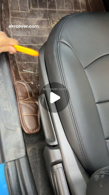 someone is cleaning the inside of a car seat with a yellow toothbrush in their hand