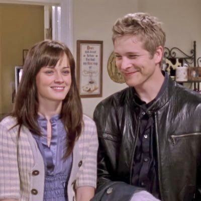 a man and woman standing next to each other in front of a kitchen counter top