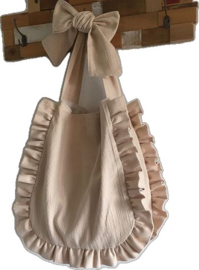 a baby's dress hanging from a wooden hanger with a bow on it