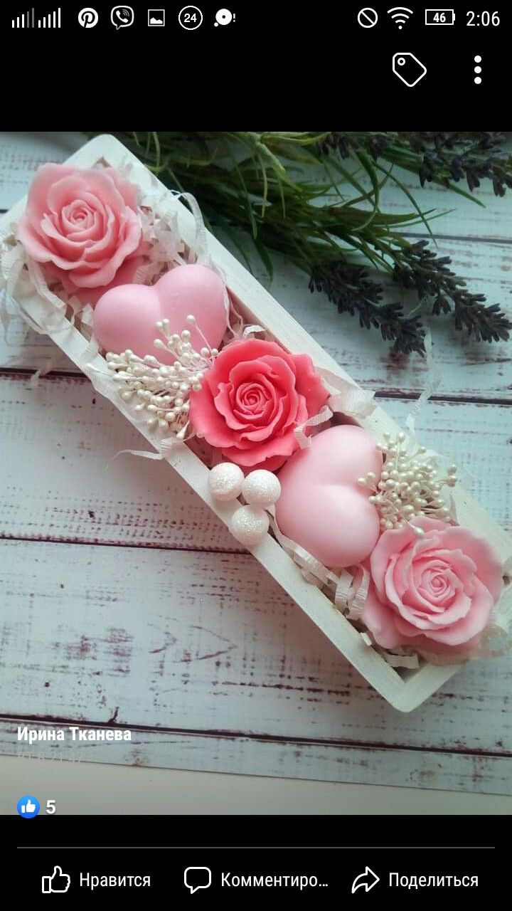 some pink roses in a white box on a wooden table with greenery and flowers