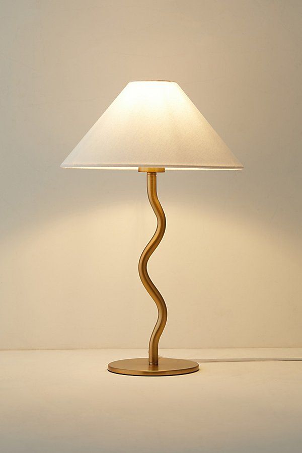 a table lamp with a white shade on it's base and a light bulb in the shape of a spiral