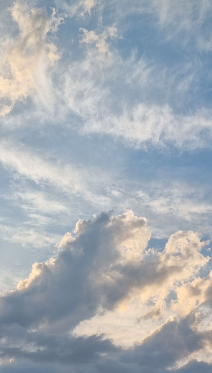 the airplane is flying high in the sky with some clouds behind it and another plane on the ground below