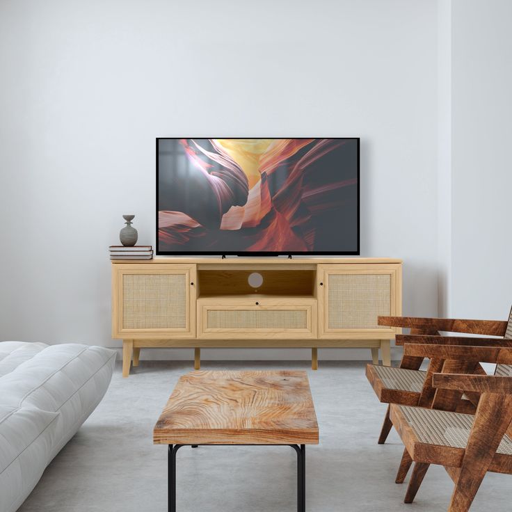 a flat screen tv sitting on top of a wooden stand in front of a white couch