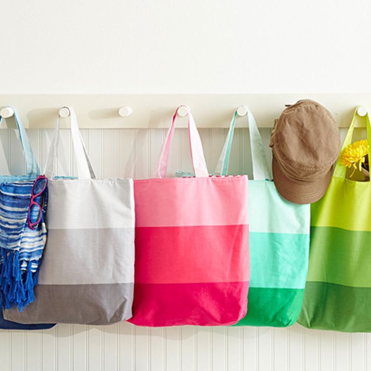 four bags hanging on the wall with flowers in them