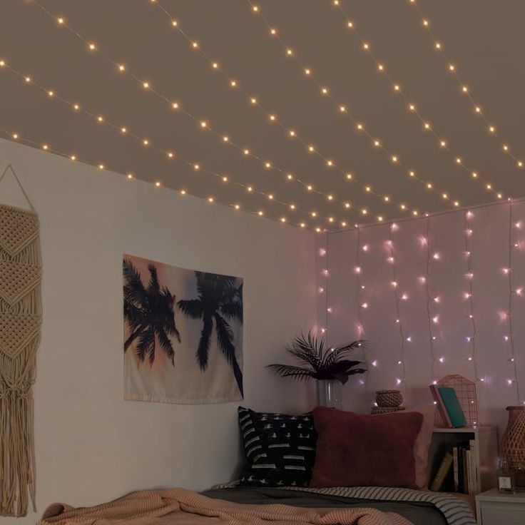 a bed room with a neatly made bed and lights on the ceiling