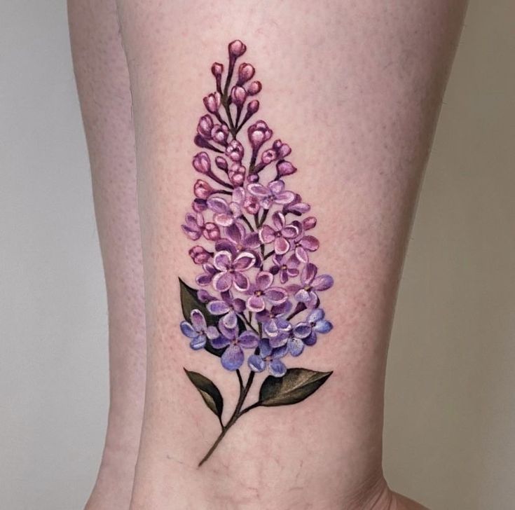 a woman's lower leg with a purple flower tattoo on her left side ribcage