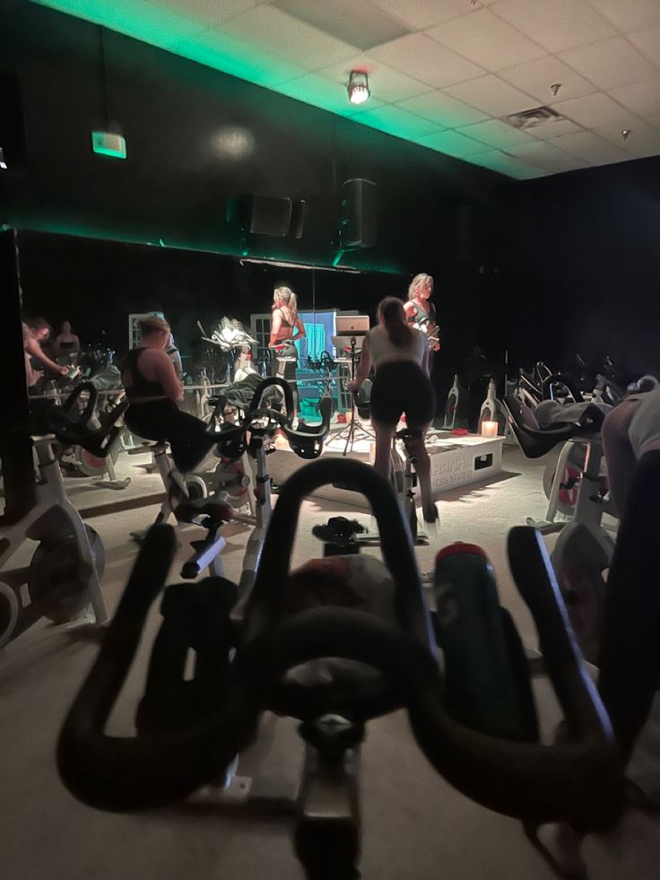 there are many people in the gym on bikes and exercise bikes at this time, while one person is using an exercise bike