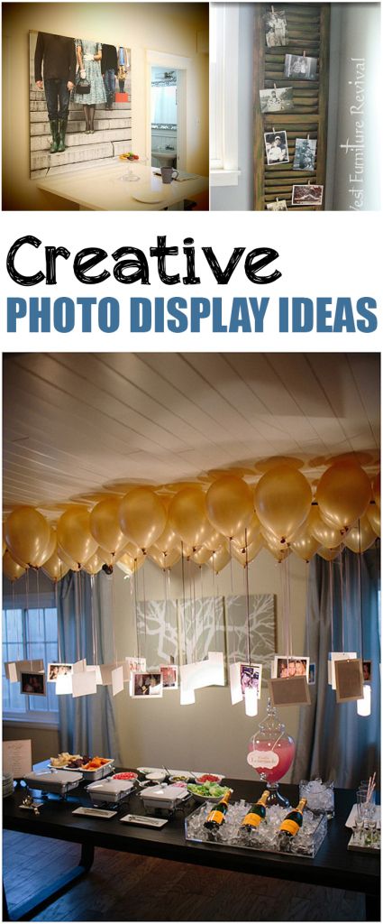 some balloons are hanging from the ceiling in front of a table with pictures on it