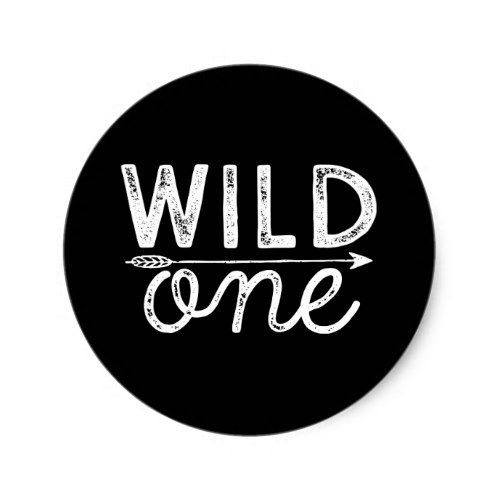 a black and white button with the words wild one written in cursive writing