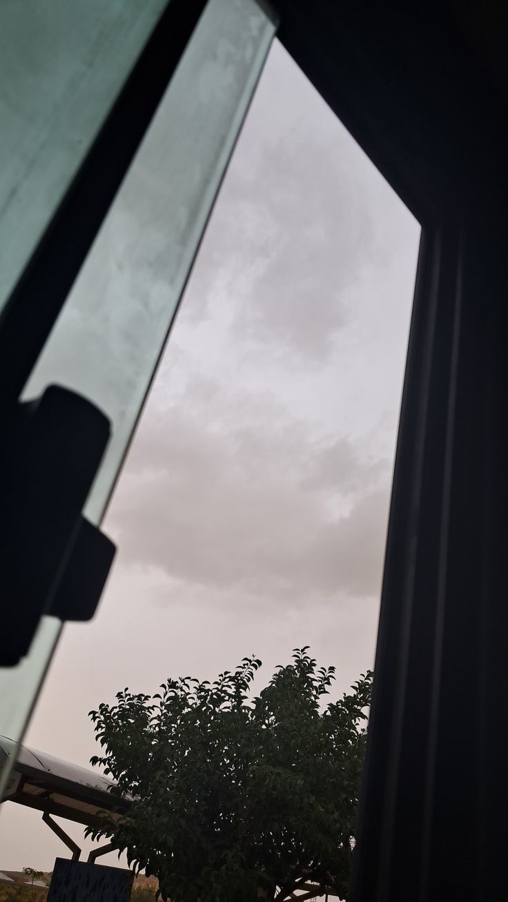 an open window looking out at the sky and trees