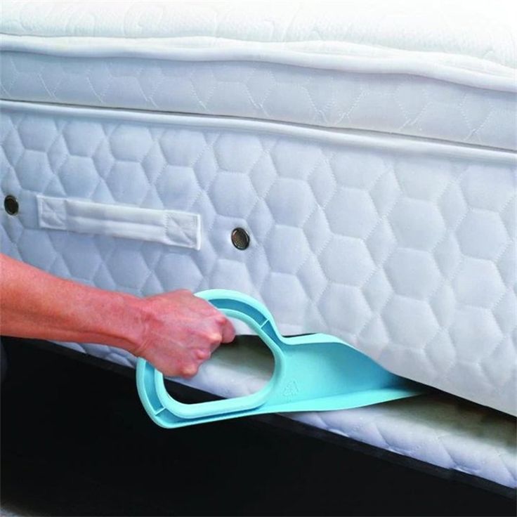 a person is opening the bottom of a mattress with a blue object in front of it