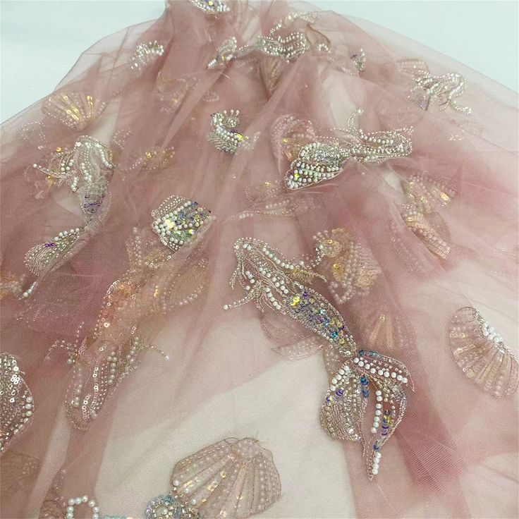 Elegant sequins beaded Mermaid sea shell ocean motif embroidered mesh lace fabric, beaded mesh fabric, sold by the yard. ☀Listing is for 1 yard. ☀Length: sell by the yard, additional quantity is available. Color: pink ☀Width: About  51''( 130 cm) ☀Material:  mesh, polyester, sequin, beads Pls kindly note, due to the material of the fabric, the edge may fray out. If you mind, pls reconsider it before place the order. For delivery time, please contact me first. Or if you have any questions, please Embellished Mermaid Wedding Dress, Sea Shell Dress, Beaded Mermaid, Motif Embroidery, Mermaid Fabric, Embroidery Lace, Sequin Beading, Pink Beads, Mermaid Tail