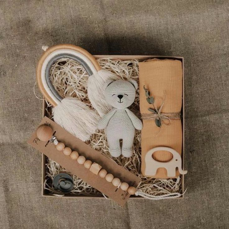 a box filled with wooden toys on top of a bed next to a stuffed animal