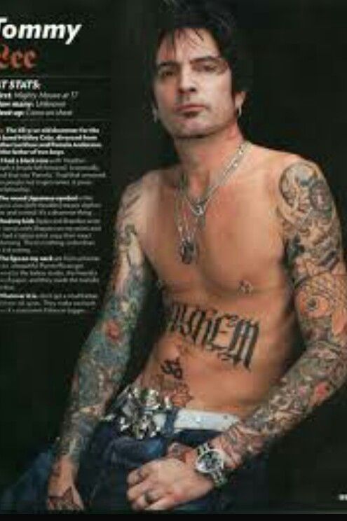 a man with many tattoos on his chest and arm is posing for a magazine cover