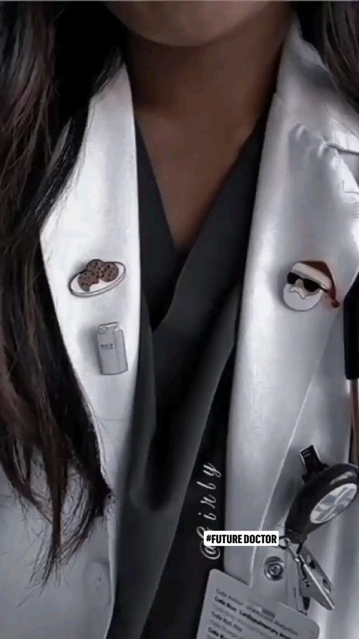 a close up of a person wearing a white coat with buttons on the lapel