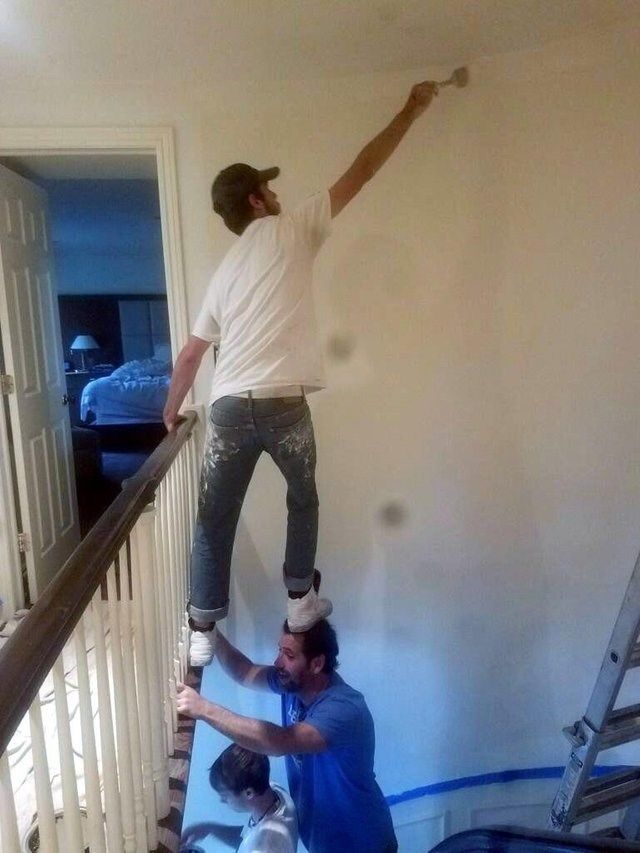 a man standing on top of a stair rail next to another man in a room