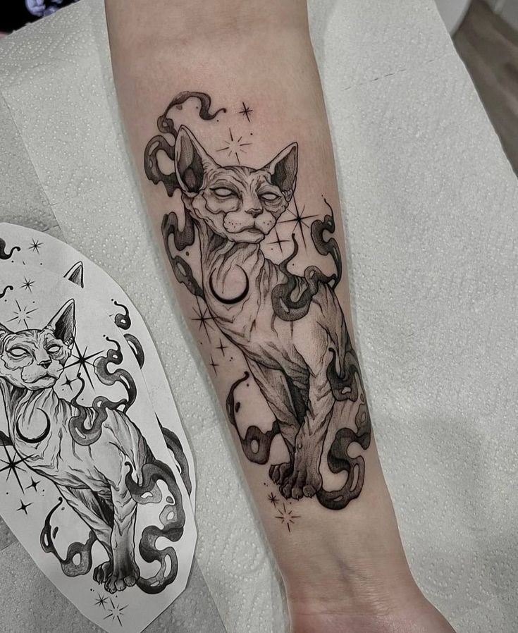 a black and white cat tattoo on the arm