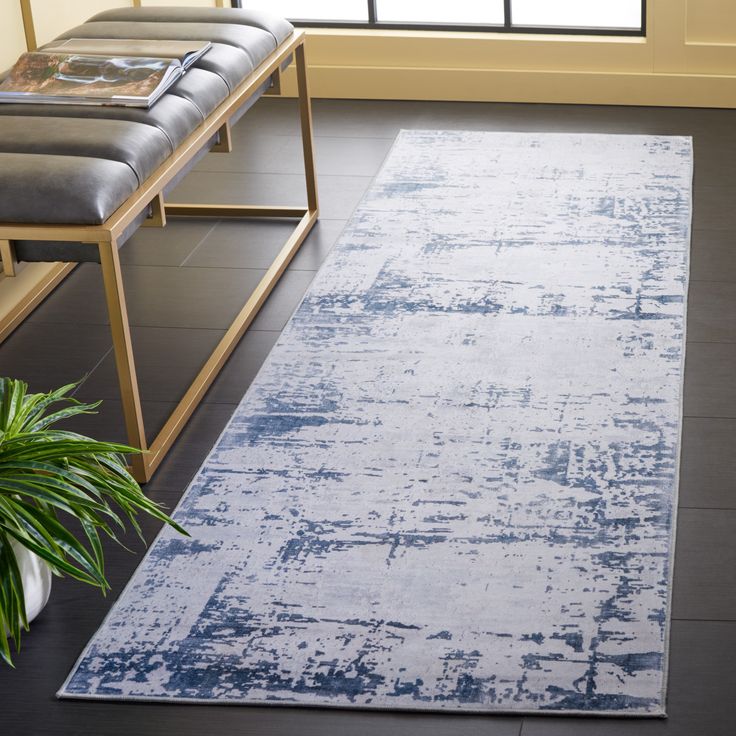 a large blue rug in the middle of a living room with a bench and potted plant