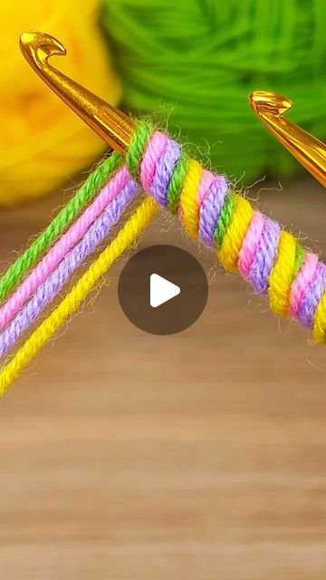 the video shows how to tie two different colored yarns with gold scissors and thread