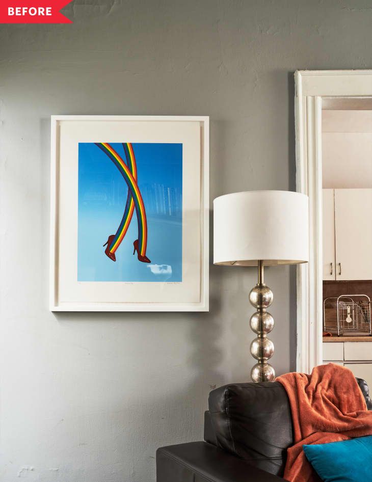 a living room with a couch, lamp and pictures on the wall