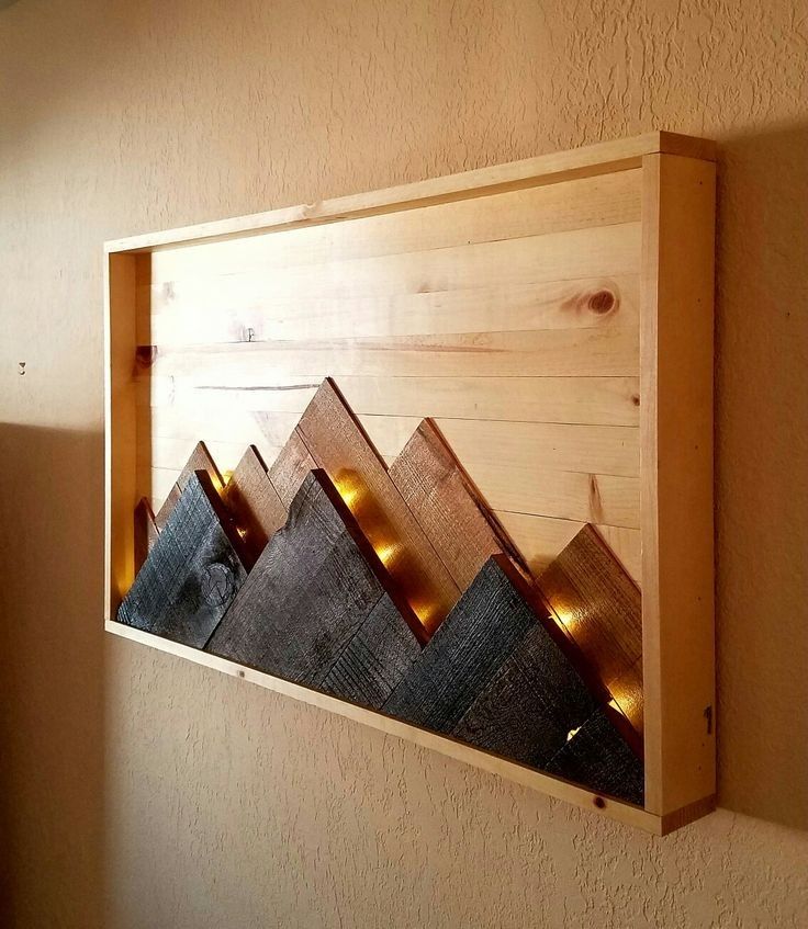 a wooden shelf with some lights on it in the shape of mountains is mounted to a wall